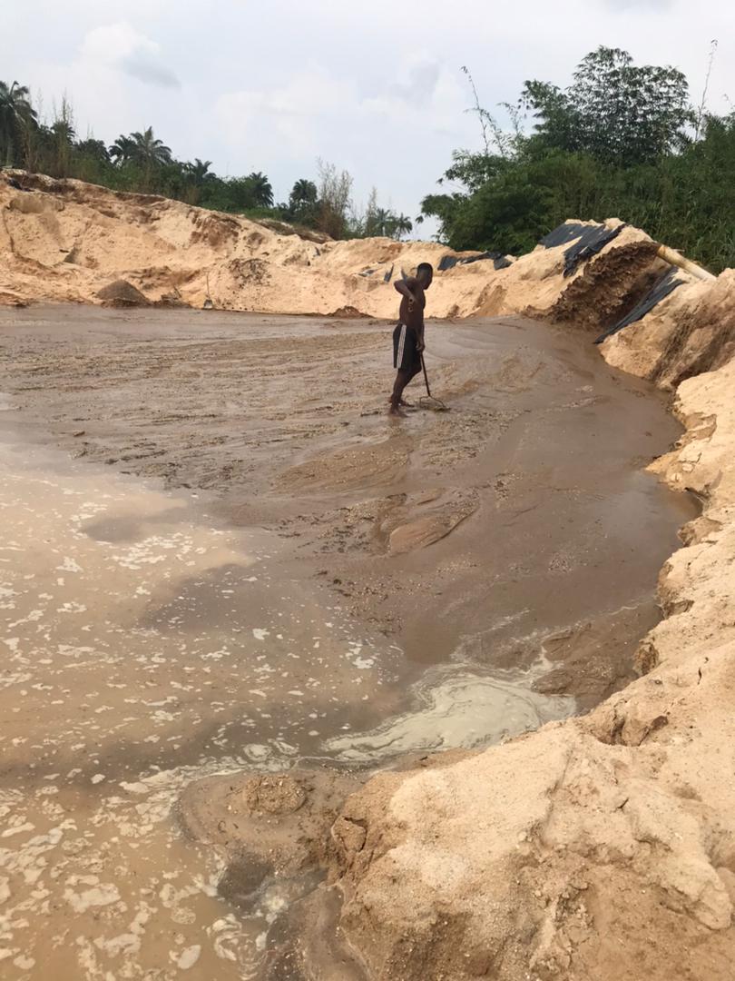 Sand bund wall containing a sand-fill area with a crew member checking levels